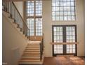 Two-story entryway boasts a staircase with black metal railing and views of the front yard through large windows at 7013 Buckhead Dr, Raleigh, NC 27615
