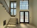 Bright foyer featuring staircase, large windows and double glass doors, all awaiting finishing touches at 7013 Buckhead Dr, Raleigh, NC 27615
