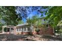 Rear exterior view showcasing the patio area, brick and siding finishes, as well as access to the private backyard space at 1210 Huntsman Dr, Durham, NC 27713