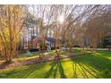 A brick home with a well manicured lawn is viewed through budding trees at 1210 Huntsman Dr, Durham, NC 27713