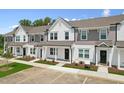 Four-unit townhome building with white and gray siding, landscaping, and parking at 124 Camel Crazies Pl # 43, Lillington, NC 27546