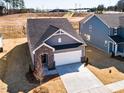 Aerial view of a well-manicured home with a two-car garage in a residential neighborhood at 213 Little Crk Dr, Lillington, NC 27546