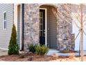 Close-up of a home entrance with a stylish black door and elegant stone accents at 213 Little Crk Dr, Lillington, NC 27546