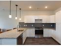 Modern kitchen with granite countertops, stainless steel appliances, and white shaker cabinets at 2206 Gathering Sq Ct # 2206, Fuquay Varina, NC 27526