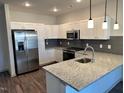 Modern kitchen features stainless steel appliances, granite countertops, and a stylish design at 2313 Gathering Square Ct # 2313, Fuquay Varina, NC 27526