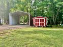 View of backyard featuring open metal carport and painted storage shed at 4139 Somerset Dr, Oxford, NC 27565