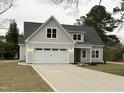 Front exterior view of gray home with dormer windows and a two-car garage at 504 Tucker St, Four Oaks, NC 27524