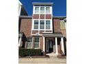 Three-story brick townhome, featuring a front door and landscaping at 549 Balsam Fir Dr Dr, Cary, NC 27519
