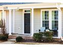 Charming home exterior with a black front door, white trim, and a cozy seating area at 6111 Kayton St, Raleigh, NC 27616