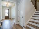 Bright entryway with hardwood floors, stairs, and a coat closet at 64 W Beech Slope Ct, Chapel Hill, NC 27517