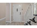 Interior entryway with white door and staircase at 7300 Grist Mill Rd, Raleigh, NC 27615
