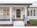 Inviting front porch with black door and white brick exterior at 7300 Grist Mill Rd, Raleigh, NC 27615