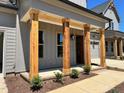 Inviting front porch featuring natural wood pillars and manicured landscaping at 1031 Coldspring Circle, Durham, NC 27705