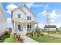 A charming two-story house featuring a quaint porch and inviting curb appeal at 129 Mossy Falls Way, Wendell, NC 27591