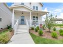 A close-up view of the entry showcasing the light blue front door and cozy porch area at 129 Mossy Falls Way, Wendell, NC 27591