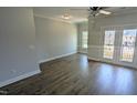 Spacious open-concept living room with wood floors, neutral paint, and a door to the balcony at 203 Broomgrove Way, Wake Forest, NC 27587