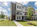 Striking townhome exterior with mixed material facade, contemporary lines, balcony, and manicured lawn at 2117 Treelight Way, Wendell, NC 27591