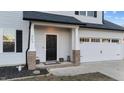 House entrance with black door, brick columns, and landscaping at 263 Langdon Chase Way, Selma, NC 27576