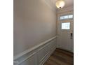 The entryway features beautiful wainscotting, wood flooring, and a front door with decorative glass at 46 Steppe Way, Garner, NC 27529