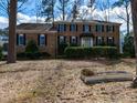 Traditional brick home with manicured hedges and mature trees on a spacious lot with lawn decorations at 501 Queensferry Rd, Cary, NC 27511