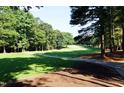A beautiful shot of the lush green golf course surrounded by mature trees and a well-maintained walking path at 501 Queensferry Rd, Cary, NC 27511
