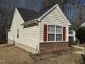 Side view of the house showcasing vinyl siding and a brick base at 6020 Newhall Rd, Durham, NC 27713