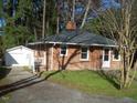 Brick house with a detached garage and driveway at 648 Linfield Dr, Durham, NC 27701