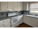 Kitchen boasts white cabinets, gray countertops, and stove at 8110 Nc 210 N, Angier, NC 27501