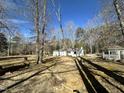 Spacious backyard surrounded by trees and featuring a gazebo on a sunny day at 8421 Falcon Crest Cir, Angier, NC 27501