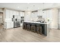 Modern kitchen with white cabinets, stainless steel appliances, and an island at 8829 Tartan Clan Dr, Willow Springs, NC 27592