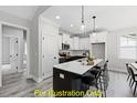 Modern kitchen with white cabinets, stainless steel appliances, and a spacious island with bar seating at 116 Mohave Dr, Louisburg, NC 27549