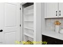 Walk-in pantry with ample shelving offers storage for all your kitchen essentials at 116 Mohave Dr, Louisburg, NC 27549
