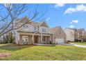 Inviting two-story home with brick and siding, two-car garage, and manicured front yard on a sunny day at 1246 Jamestowne Dr, Elon, NC 27244