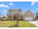 Charming two-story home featuring a brick facade, a two-car garage, and a well-maintained lawn at 1246 Jamestowne Dr, Elon, NC 27244