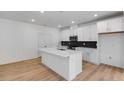 Modern kitchen featuring an island, stainless steel appliances, and sleek white cabinetry at 1264 Hardin Hill Ln, Knightdale, NC 27545