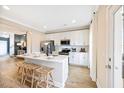 Modern kitchen with white cabinets, stainless steel appliances, an island and barstool seating at 201 Broomgrove Way, Wake Forest, NC 27587