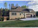 Exterior view of a home with a screened porch, patio, and large yard with a view of mature trees at 3913 Cedar Knolls # 7, Youngsville, NC 27596