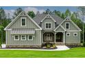Close up of a home's facade featuring gray siding, stone accents, and well-kept landscaping at 3913 Cedar Knolls # 7, Youngsville, NC 27596