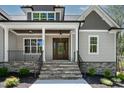 Inviting front porch with stone steps, black railings, and a beautiful wood door entrance at 3923 Cedar Knolls Dr # 12, Youngsville, NC 27596