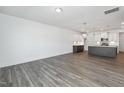 Open-concept living space featuring modern lighting, wood-look flooring, leading into the stylish, contemporary kitchen at 3935 Willow Gate Way, Knightdale, NC 27604
