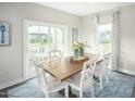 Bright dining room with wooden table, sliding glass door to deck at 600 Mohinda Way, Willow Springs, NC 27592