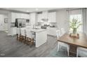 Open concept kitchen with white cabinets, granite island and breakfast area at 600 Mohinda Way, Willow Springs, NC 27592