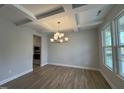 Bright dining room featuring hardwood floors, coffered ceilings and stylish light fixture at 752 Portland Rose Dr, Knightdale, NC 27545