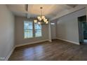 Bright dining room featuring hardwood floors, modern chandelier and abundant natural light at 752 Portland Rose Dr, Knightdale, NC 27545