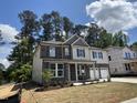 Beautiful two-story home with stone accents, a covered porch, manicured landscaping and a three-car garage at 752 Portland Rose Dr, Knightdale, NC 27545