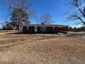 Brick ranch house with covered porch and large yard at 1002 Godwin Ln, Dunn, NC 28334