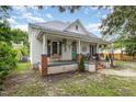White farmhouse with a welcoming front porch and landscaping at 1006 W Broad St, Dunn, NC 28334