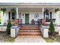 Inviting front porch with brick steps and hanging plants at 1006 W Broad St, Dunn, NC 28334