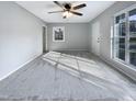 Bright living room with large windows and ceiling fan at 1100 Somerset Rd, Raleigh, NC 27610