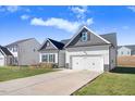 Newly built home with gray and white exterior, two-car garage, and landscaping at 142 Jade St, Smithfield, NC 27577
